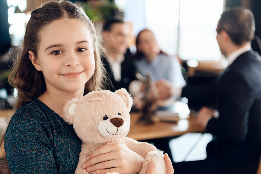 child holding a teddy bear in lawyer's office